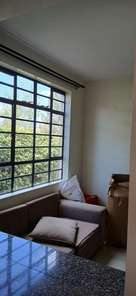 Comfortable sofa and unpacked lounge nook arranged next to large window